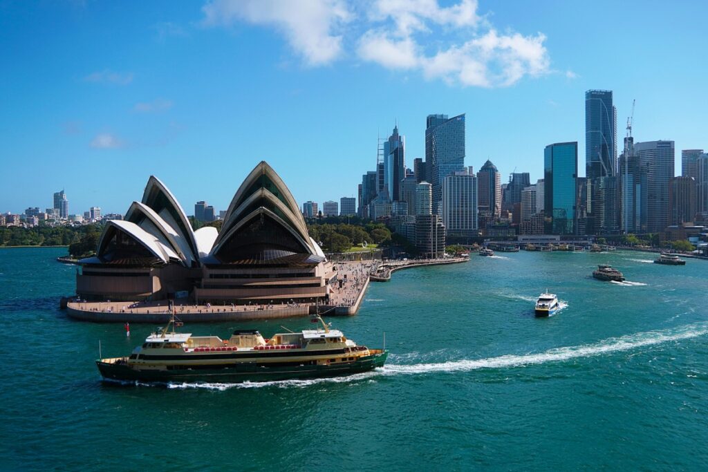 A stunning view of the iconic Sydney Opera House surrounded by the clear blue waters of Sydney Harbour, with ferries cruising by and the modern city skyline in the background. Just as this view captures the essence of Australia's vibrant landscape, "Snapchat Trends in Australia: What’s Hot in 2025" explores the dynamic social media scene in the country.